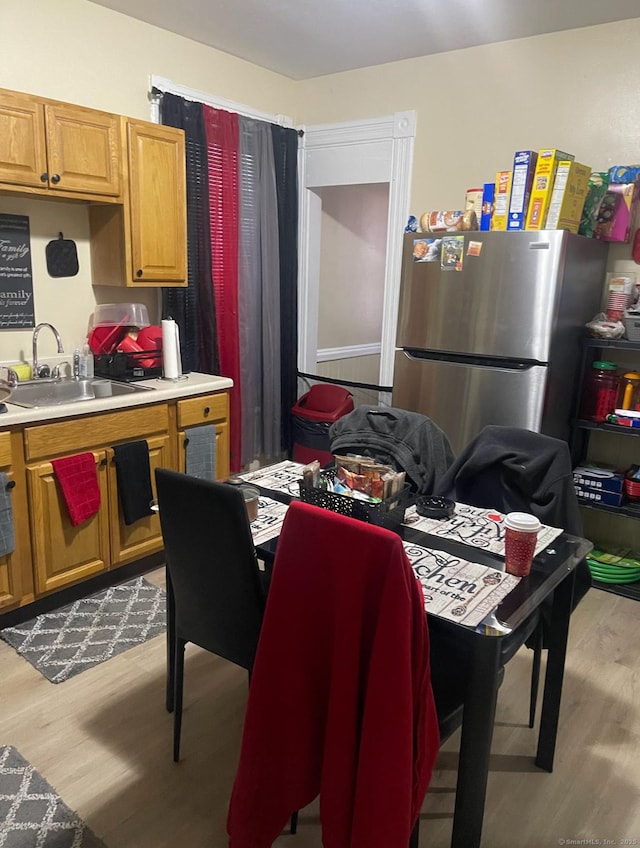 115 Lloyd St, New Haven, CT 06513 - kitchen with freestanding refrigerator, light wood finished floors, light countertops, and brown cabinetry