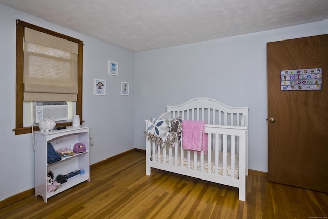 26 Sandpiper Rd, Enfield, CT 06082 - bedroom featuring wood finished floors, cooling unit, and a nursery area