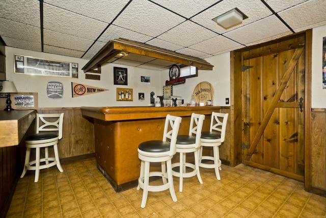 26 Sandpiper Rd, Enfield, CT 06082 - indoor dry bar with tile patterned floors, a drop ceiling, wooden walls, and wainscoting