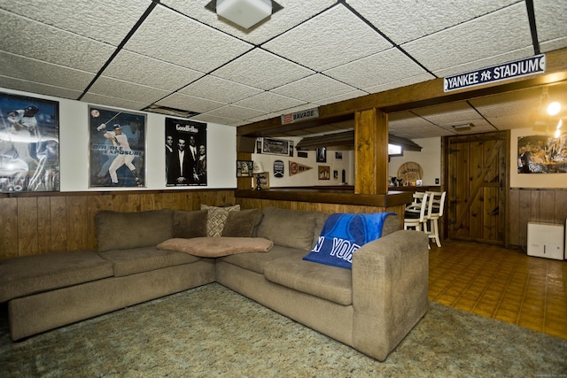 26 Sandpiper Rd, Enfield, CT 06082 - living room with a drop ceiling, a wainscoted wall, wood walls, and tile patterned floors