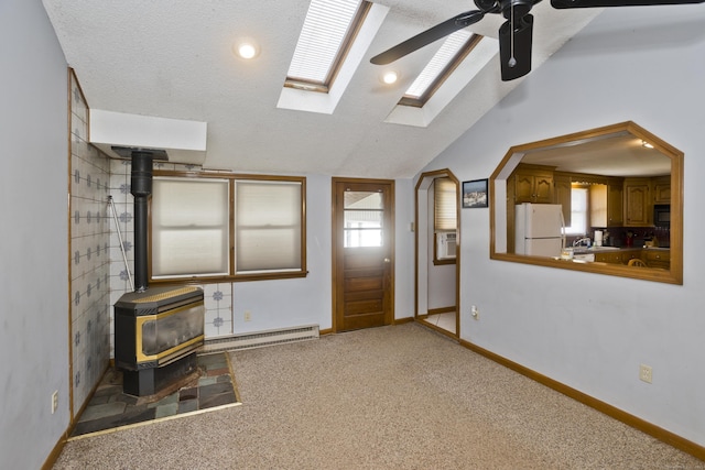 26 Sandpiper Rd, Enfield, CT 06082 - unfurnished living room with a wood stove, a baseboard radiator, a ceiling fan, vaulted ceiling, and carpet floors