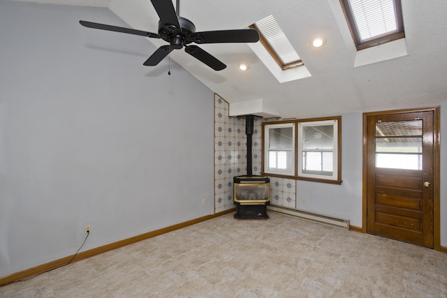 26 Sandpiper Rd, Enfield, CT 06082 - empty room featuring a baseboard heating unit, lofted ceiling, a wood stove, a skylight, and ceiling fan