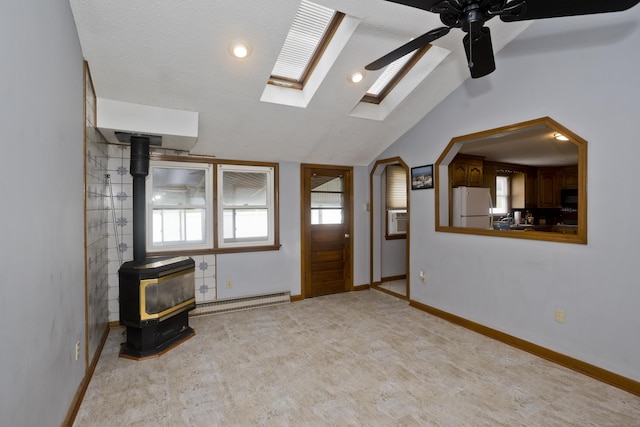 26 Sandpiper Rd, Enfield, CT 06082 - foyer with baseboard heating, a wood stove, a ceiling fan, vaulted ceiling, and a skylight