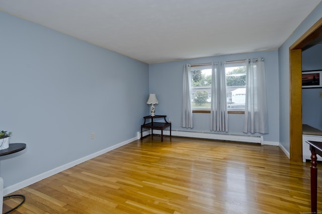 26 Sandpiper Rd, Enfield, CT 06082 - empty room with a baseboard heating unit and light wood-type flooring