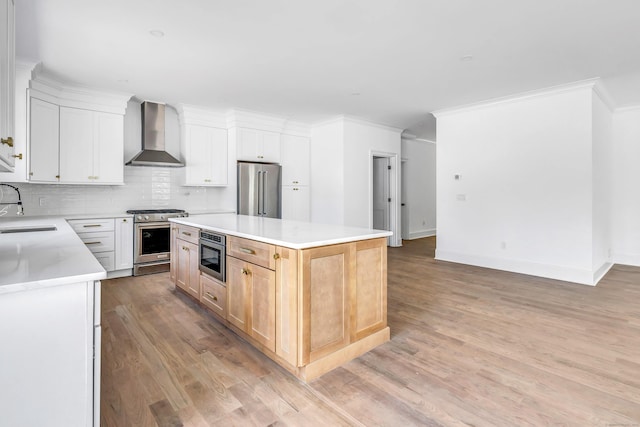 LotA Roseville Street, Fairfield, CT 06825 - kitchen with premium appliances, wall chimney range hood, light wood-style flooring, tasteful backsplash, and light countertops