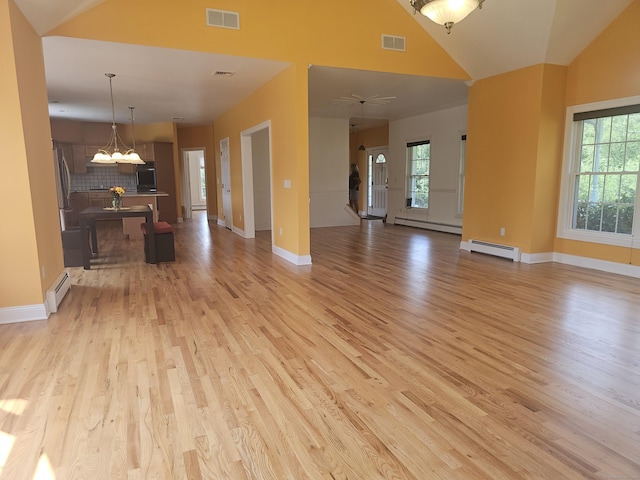 41 Mesa Dr, Bethany, CT 06524 - unfurnished living room with a baseboard heating unit, light wood-style floors, a chandelier, and high vaulted ceiling
