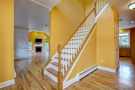41 Mesa Dr, Bethany, CT 06524 - stairs featuring a baseboard heating unit, wood finished floors, and a fireplace