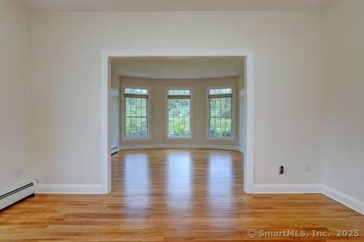 41 Mesa Dr, Bethany, CT 06524 - empty room with light wood finished floors and a baseboard heating unit