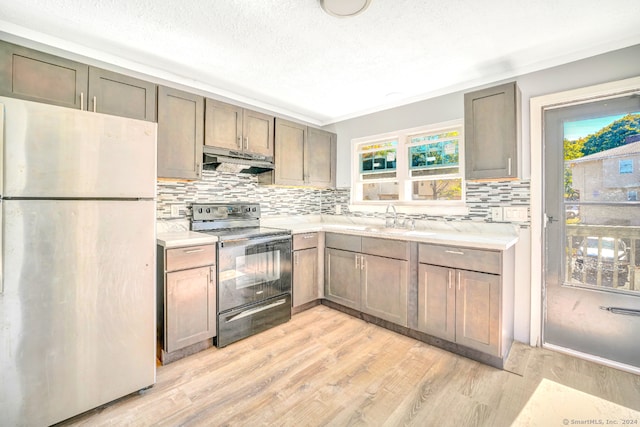 50 Angel Dr Apt D, Waterbury, CT 06708 - kitchen with freestanding refrigerator, black / electric stove, range hood, backsplash, and light countertops