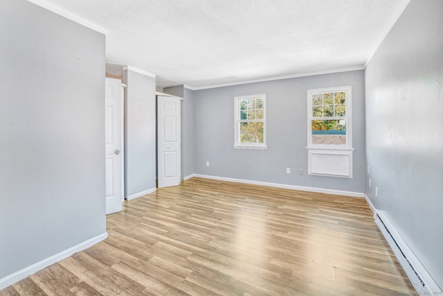50 Angel Dr Apt D, Waterbury, CT 06708 - empty room with a baseboard heating unit, a textured ceiling, light wood-type flooring, and ornamental molding