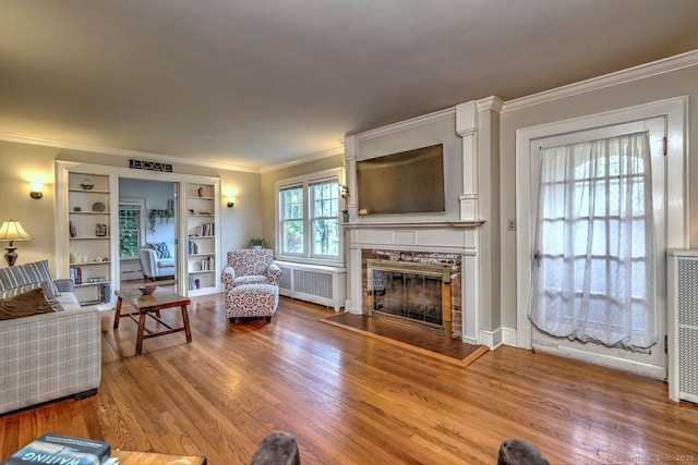 345 Spring St, Cheshire, CT 06410 - living area with radiator, a tile fireplace, crown molding, and wood finished floors