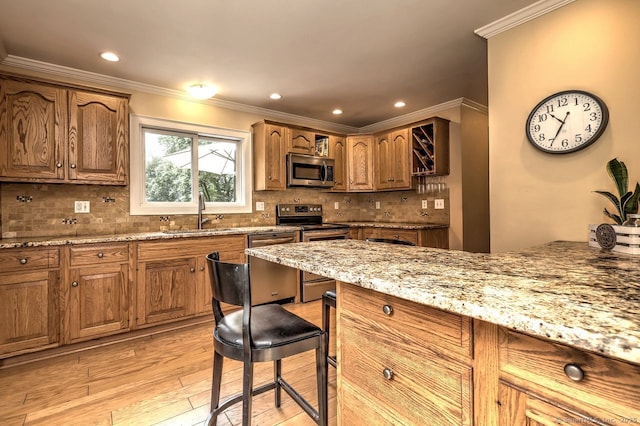 345 Spring St, Cheshire, CT 06410 - kitchen with appliances with stainless steel finishes, a breakfast bar area, light wood finished floors, light stone countertops, and ornamental molding