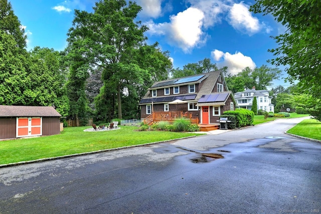 345 Spring St, Cheshire, CT 06410 - shingle-style home featuring a fire pit, roof mounted solar panels, a deck, and a shed