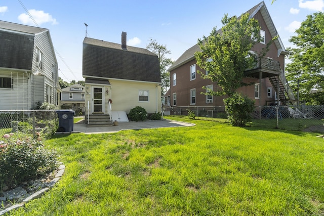 169 Peck Ave, West Haven, CT 06516 - rear view of house with a shingled roof, entry steps, a chimney, and a fenced backyard