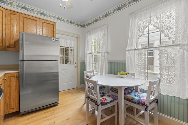 169 Peck Ave, West Haven, CT 06516 - dining space with light wood-style flooring, a wainscoted wall, and a ceiling fan