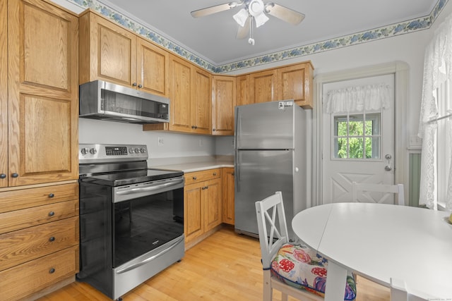 169 Peck Ave, West Haven, CT 06516 - kitchen with stainless steel appliances, light wood-type flooring, light countertops, a ceiling fan, and brown cabinetry