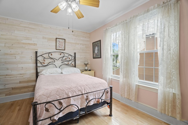 169 Peck Ave, West Haven, CT 06516 - bedroom with wood walls, wood finished floors, crown molding, a ceiling fan, and an accent wall