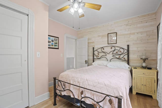 169 Peck Ave, West Haven, CT 06516 - bedroom featuring wooden walls, light wood-type flooring, ornamental molding, an accent wall, and a ceiling fan