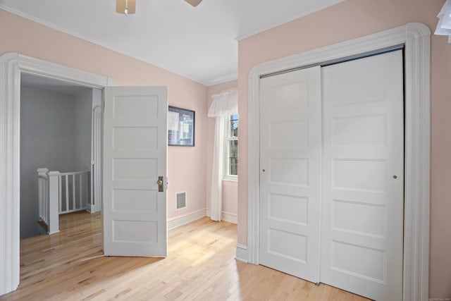 169 Peck Ave, West Haven, CT 06516 - unfurnished bedroom with light wood-style flooring, a closet, crown molding, and a ceiling fan