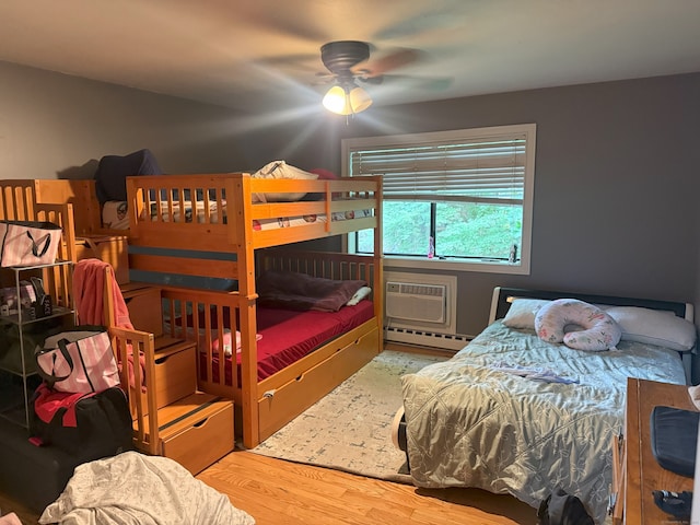 38 Padanaram Ave Unit 24, Danbury, CT 06811 - bedroom featuring a baseboard heating unit, a wall mounted AC, and wood finished floors