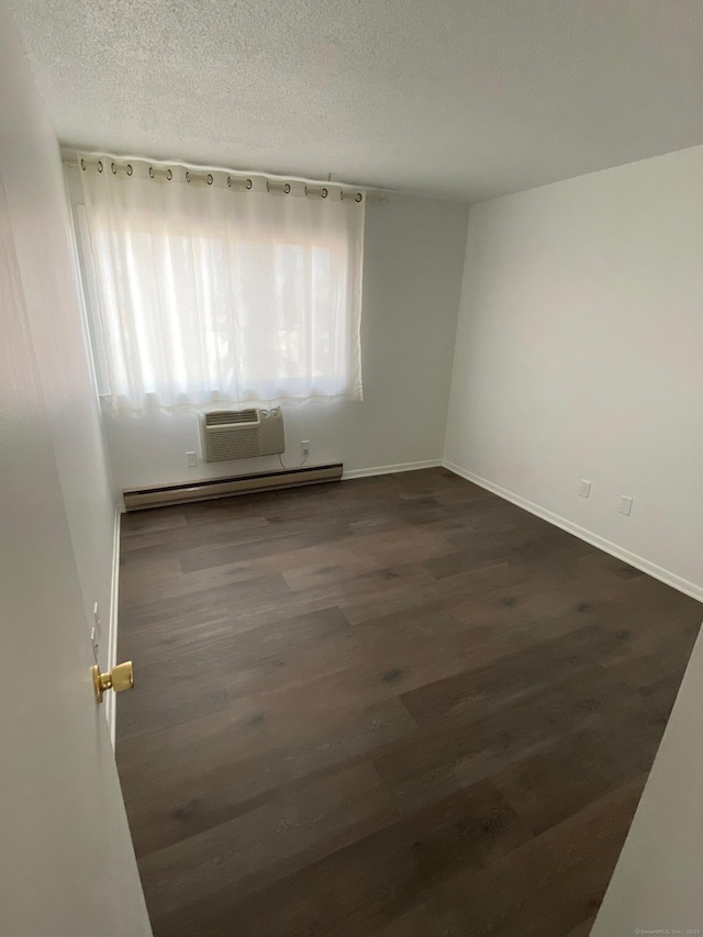 255 Strawberry Hill Ave Unit D4, Stamford, CT 06902 - empty room with a wall mounted AC, dark wood-type flooring, a baseboard heating unit, and a textured ceiling