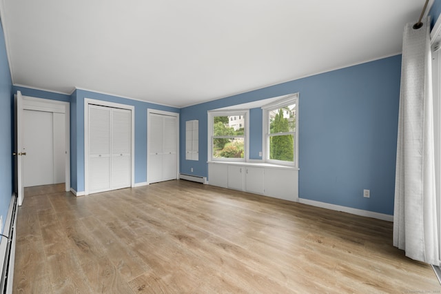 8 Griswold Dr, East Lyme, CT 06357 - unfurnished bedroom featuring multiple closets, light wood-style flooring, a baseboard heating unit, and crown molding