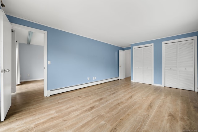 8 Griswold Dr, East Lyme, CT 06357 - unfurnished bedroom with a baseboard radiator, multiple closets, crown molding, and light wood-style floors
