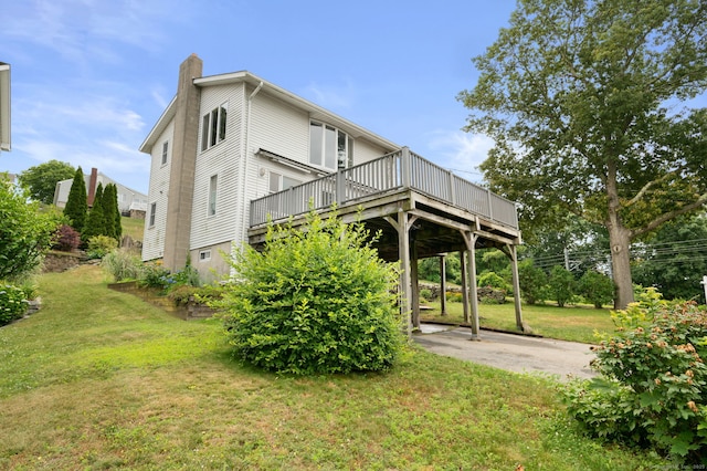 8 Griswold Dr, East Lyme, CT 06357 - back of property featuring a chimney, a yard, and a wooden deck