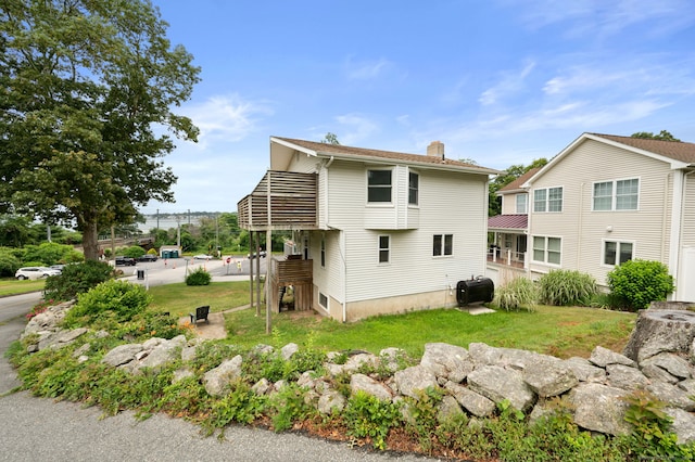 8 Griswold Dr, East Lyme, CT 06357 - back of house with a chimney and a lawn