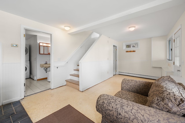 8 Griswold Dr, East Lyme, CT 06357 - living area featuring a baseboard heating unit, stacked washer / dryer, wainscoting, and stairs