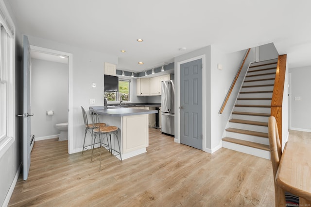 8 Griswold Dr, East Lyme, CT 06357 - kitchen with freestanding refrigerator, a peninsula, light wood-style flooring, a kitchen bar, and recessed lighting