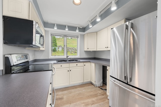 8 Griswold Dr, East Lyme, CT 06357 - kitchen featuring stainless steel appliances, track lighting, light wood-style floors, dark countertops, and white cabinetry