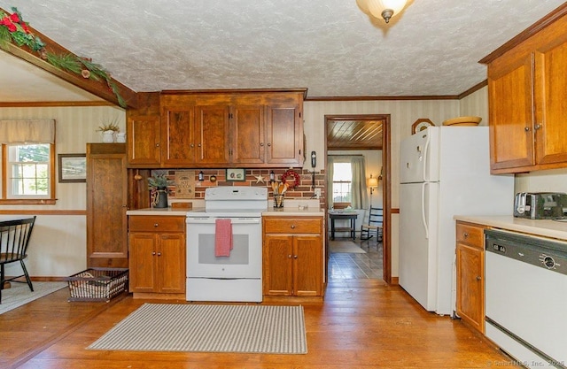 39 Mohawk Ln, Wethersfield, CT 06109 - kitchen featuring white appliances, hardwood / wood-style floors, light countertops, brown cabinetry, and crown molding