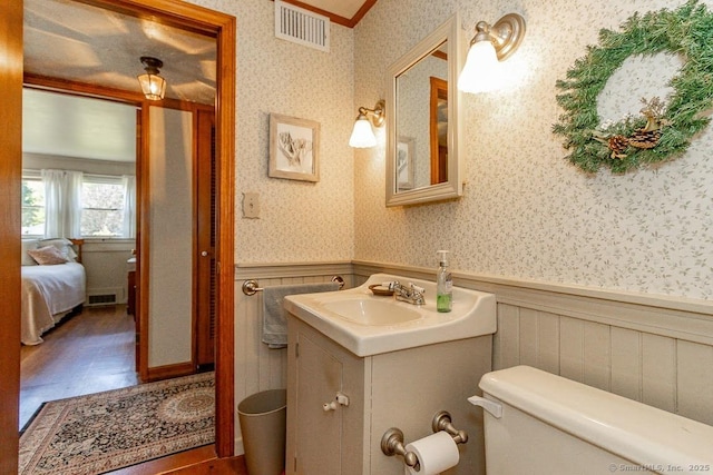 39 Mohawk Ln, Wethersfield, CT 06109 - bathroom with wallpapered walls, a wainscoted wall, vanity, and wood finished floors