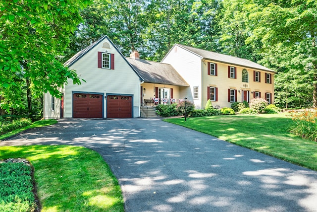 135 Harvest Woods Rd, Middlefield, CT 06481 - colonial-style house with asphalt driveway, a chimney, and a front yard
