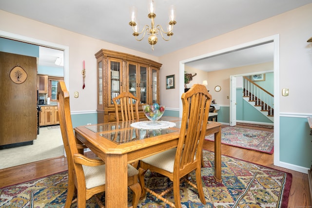 135 Harvest Woods Rd, Middlefield, CT 06481 - dining space with a chandelier, wood finished floors, and stairs