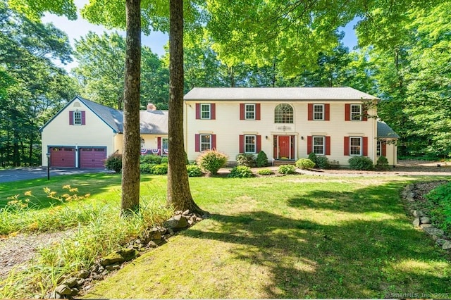 135 Harvest Woods Rd, Middlefield, CT 06481 - colonial house featuring a detached garage, a front lawn, and view of wooded area