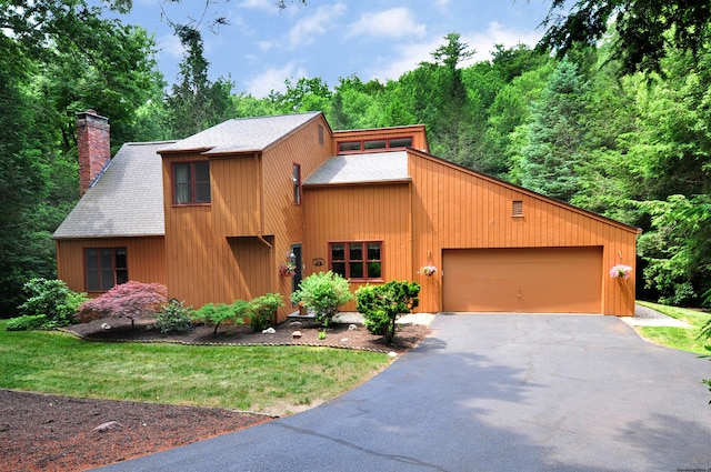 11 Brianwood Ln, Granby, CT 06035 - view of front of home with a garage, a chimney, driveway, and roof with shingles