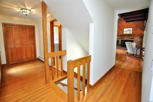 11 Brianwood Ln, Granby, CT 06035 - hall featuring baseboard heating, an upstairs landing, light wood-type flooring, and wood walls