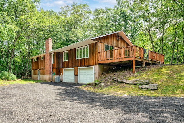1037 Bartholomew Rd, Middletown, CT 06457 - view of front of house with board and batten siding, an attached garage, a chimney, and a wooden deck