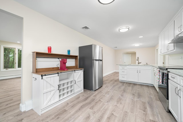 1037 Bartholomew Rd, Middletown, CT 06457 - kitchen with appliances with stainless steel finishes, a peninsula, light wood-style flooring, white cabinets, and baseboard heating