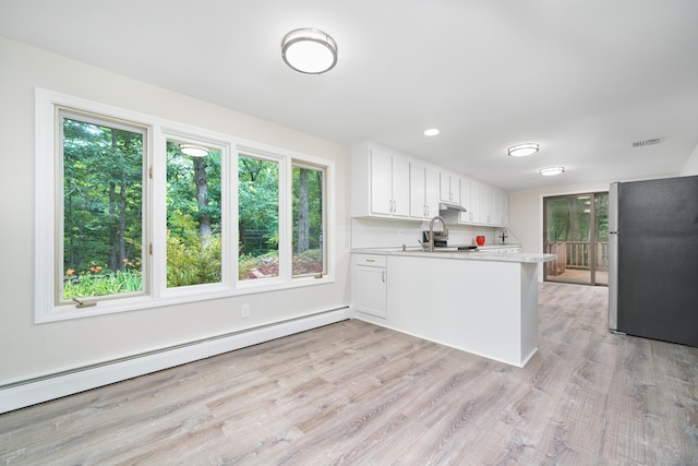 1037 Bartholomew Rd, Middletown, CT 06457 - kitchen featuring freestanding refrigerator, baseboard heating, a peninsula, light countertops, and under cabinet range hood