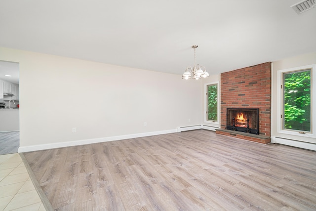 1037 Bartholomew Rd, Middletown, CT 06457 - unfurnished living room featuring light wood-type flooring, a chandelier, a brick fireplace, baseboard heating, and a baseboard heating unit