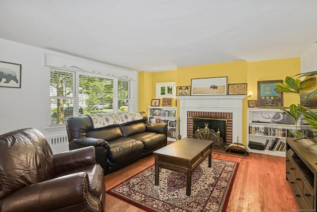 57 Lakeview Ave, Hamden, CT 06514 - living area with wood finished floors, radiator heating unit, and a brick fireplace