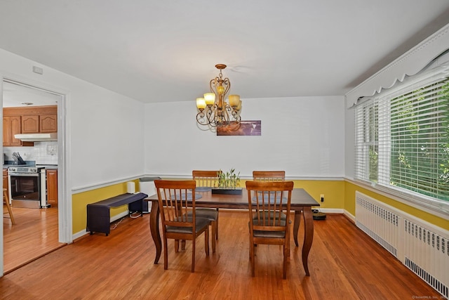 57 Lakeview Ave, Hamden, CT 06514 - dining area featuring radiator, light wood-style flooring, and a chandelier