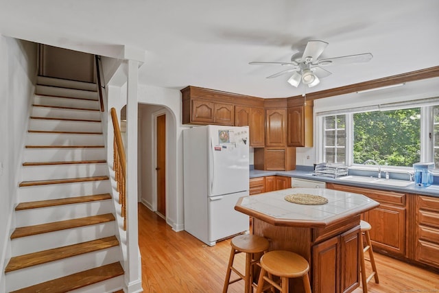 57 Lakeview Ave, Hamden, CT 06514 - kitchen with white appliances, light wood-type flooring, a kitchen bar, and tile countertops
