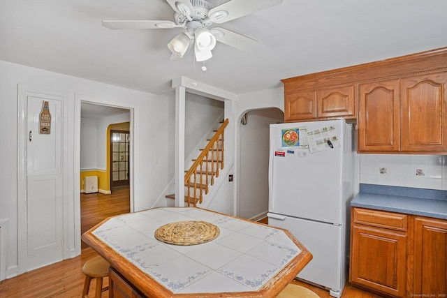 57 Lakeview Ave, Hamden, CT 06514 - kitchen featuring freestanding refrigerator, tile countertops, tasteful backsplash, ceiling fan, and light wood finished floors