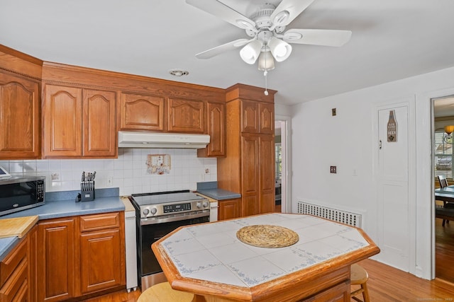57 Lakeview Ave, Hamden, CT 06514 - kitchen with appliances with stainless steel finishes, under cabinet range hood, a ceiling fan, tile countertops, and tasteful backsplash