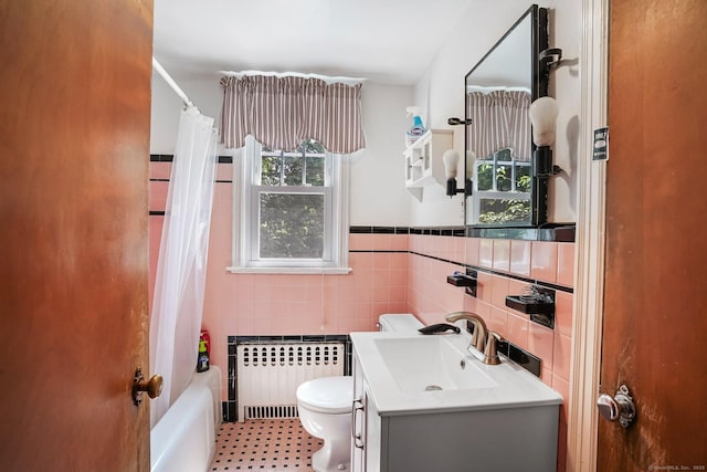 57 Lakeview Ave, Hamden, CT 06514 - bathroom with radiator, tile walls, vanity, shower / tub combo with curtain, and a wainscoted wall