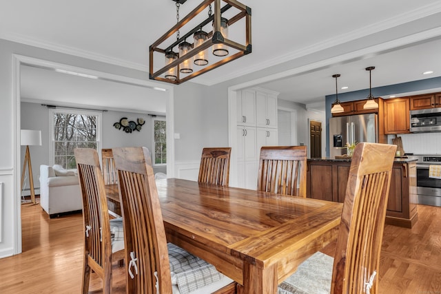 60 Ledgeview Ln, Guilford, CT 06437 - dining room featuring baseboard heating, light wood finished floors, a chandelier, ornamental molding, and wainscoting